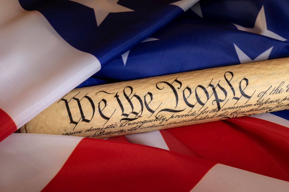 American Flag and rolled up Constitution