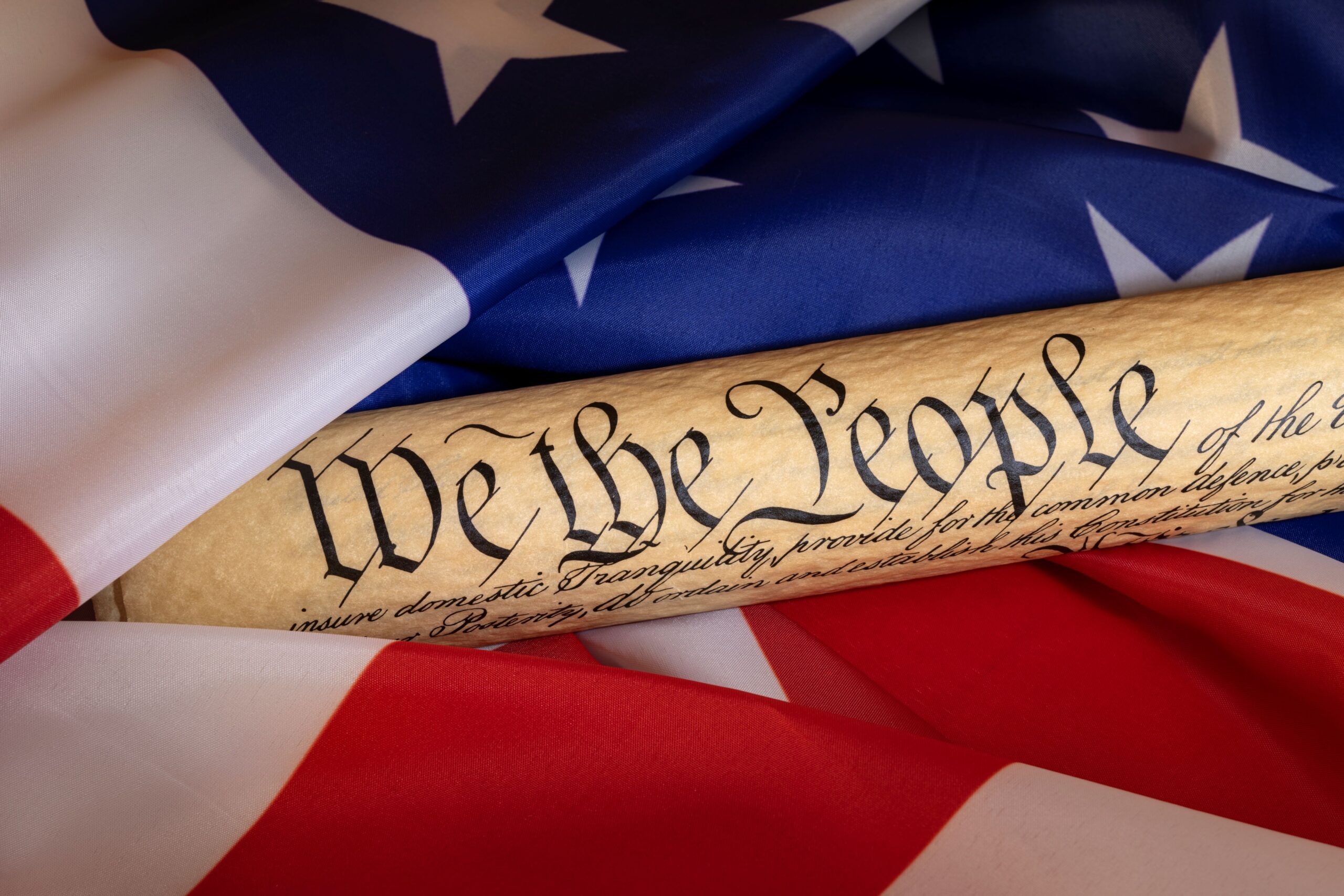 American Flag and rolled up Constitution