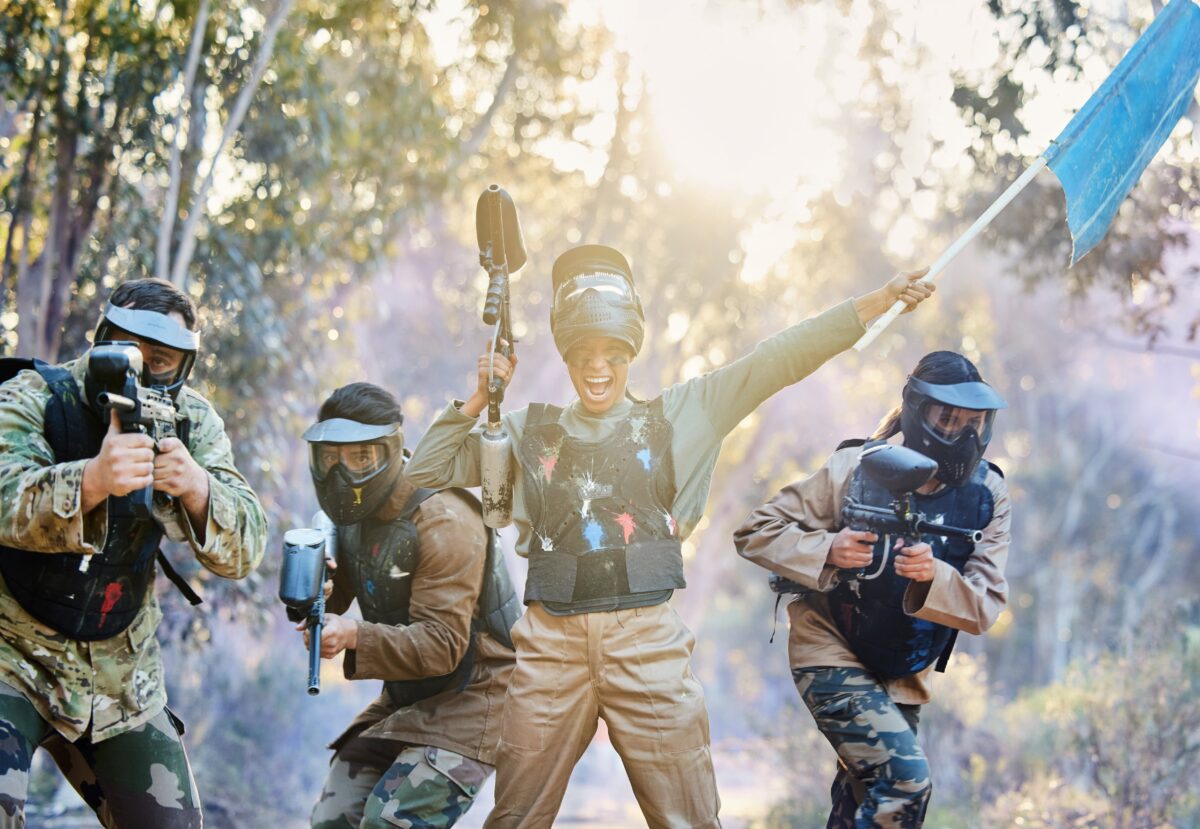People playing capture the flag with paintball guns are so happy that they won!