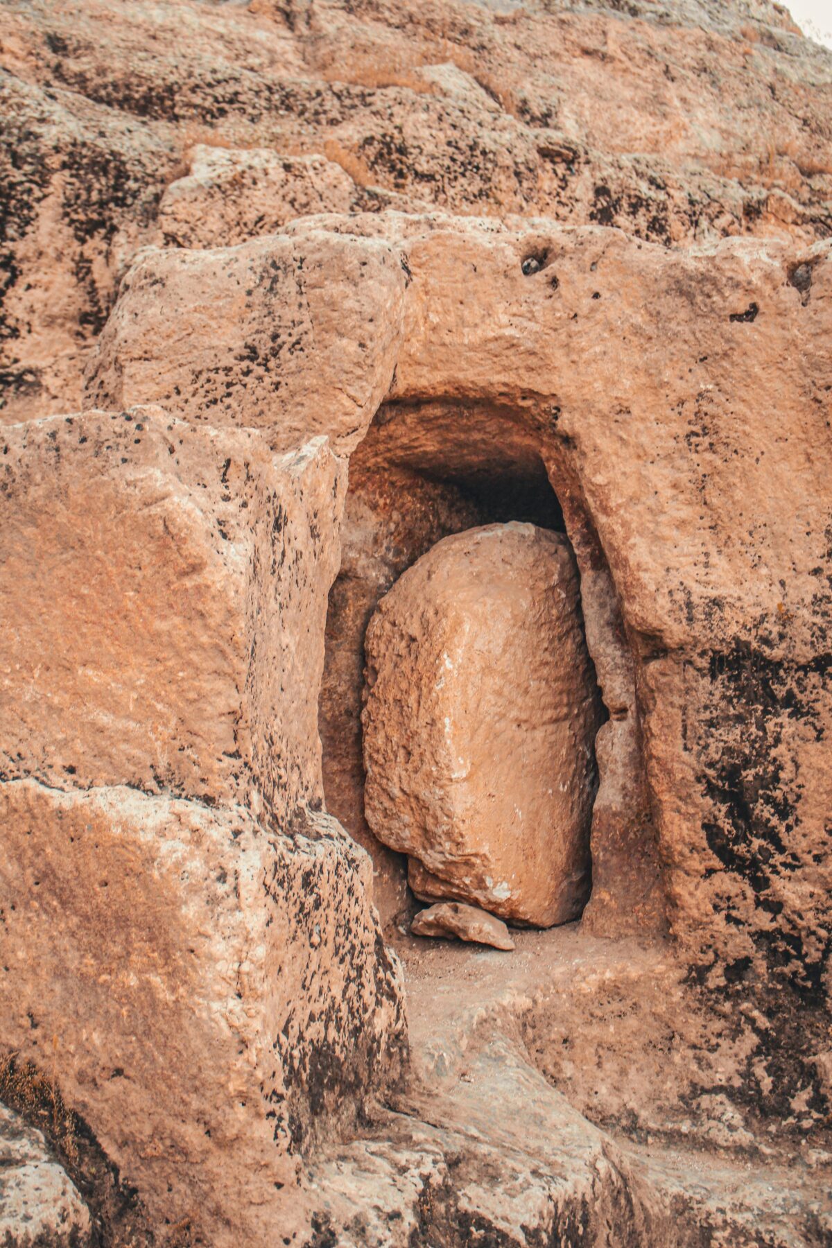 An ancient tomb with a round stone sealing it closed.